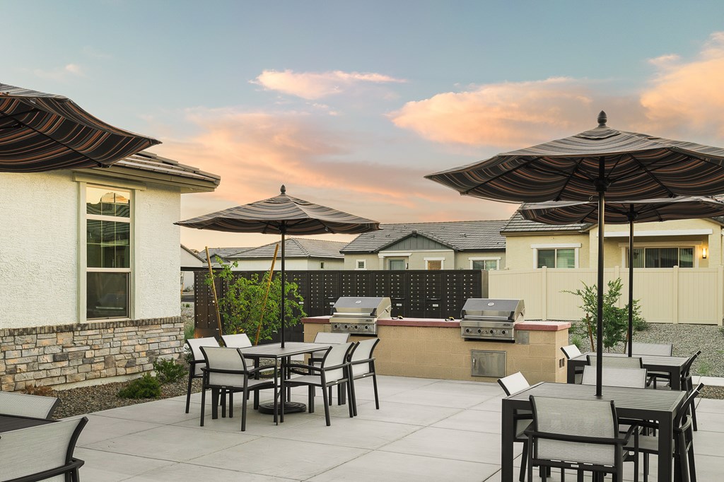A patio with a table and chairs under umbrellas.