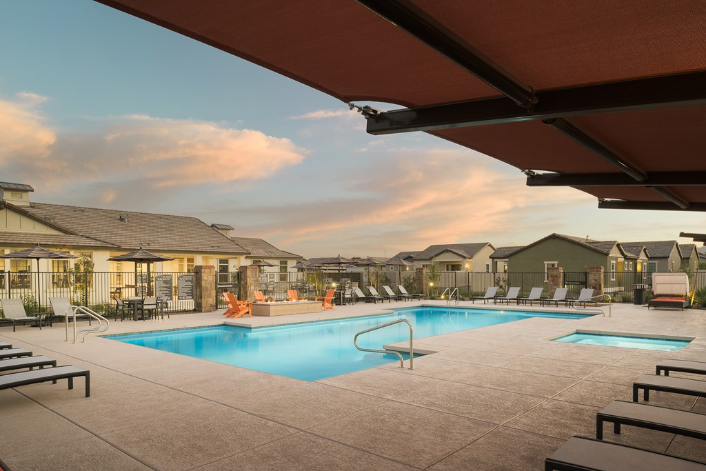 A swimming pool surrounded by lounge chairs and umbrellas.