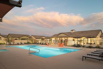 A large swimming pool surrounded by lounge chairs and umbrellas.