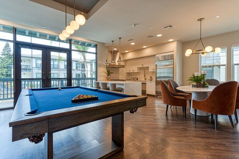 A pool table with a green felt cloth and white cue ball and red balls.