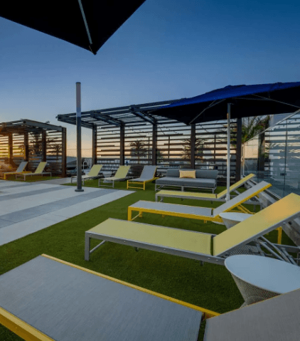 a patio with lounge chairs and umbrellas at a resort