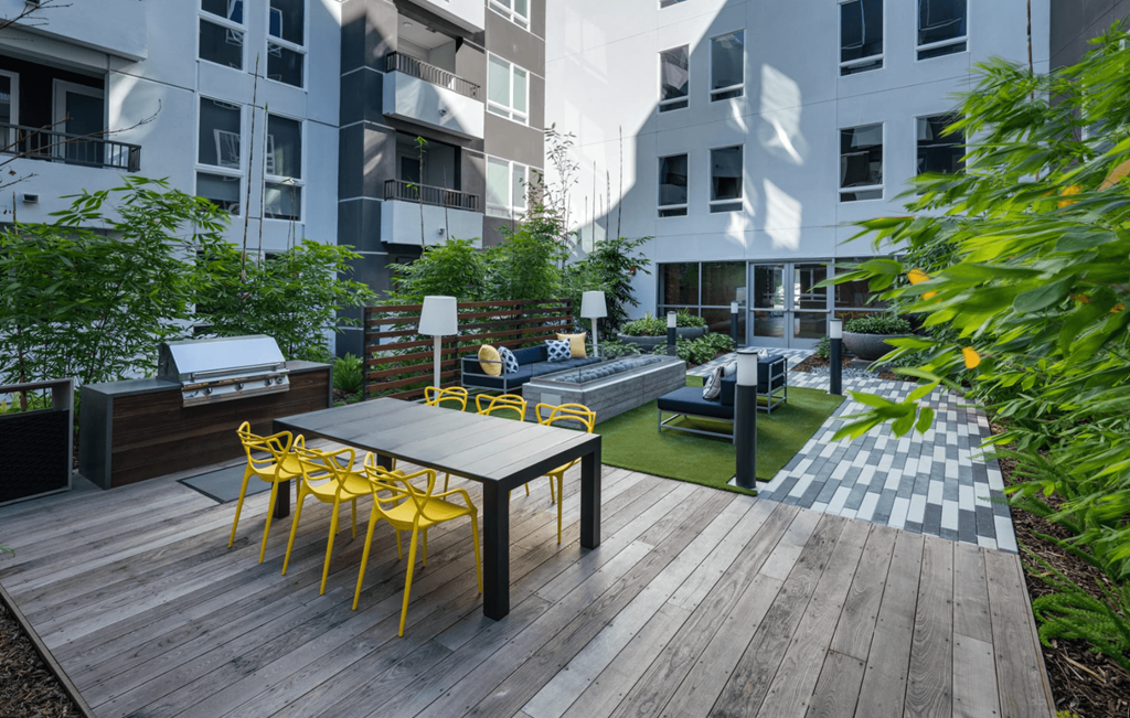 a communal area with a table and chairs on a wooden deck