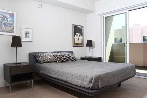 A bedroom with a bed, nightstands, and a poster on the wall at Wilshire Valencia Apartment, Los Angeles, 90017