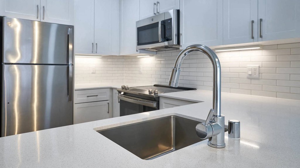 a kitchen with a sink and a stainless steel refrigerator at Avenue Two Apartments, California