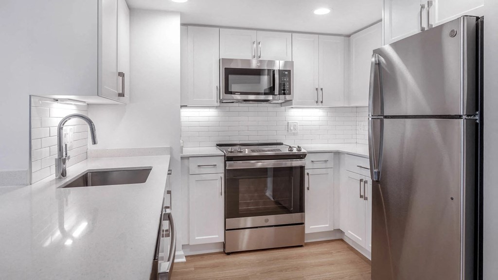 a kitchen with white cabinets and stainless steel appliances at Avenue Two Apartments, California, 94063