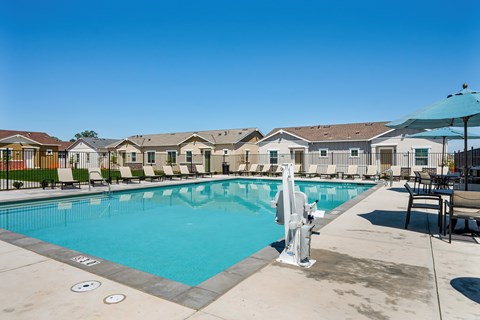 A pool with a diving board and a fountain in the middle of it.