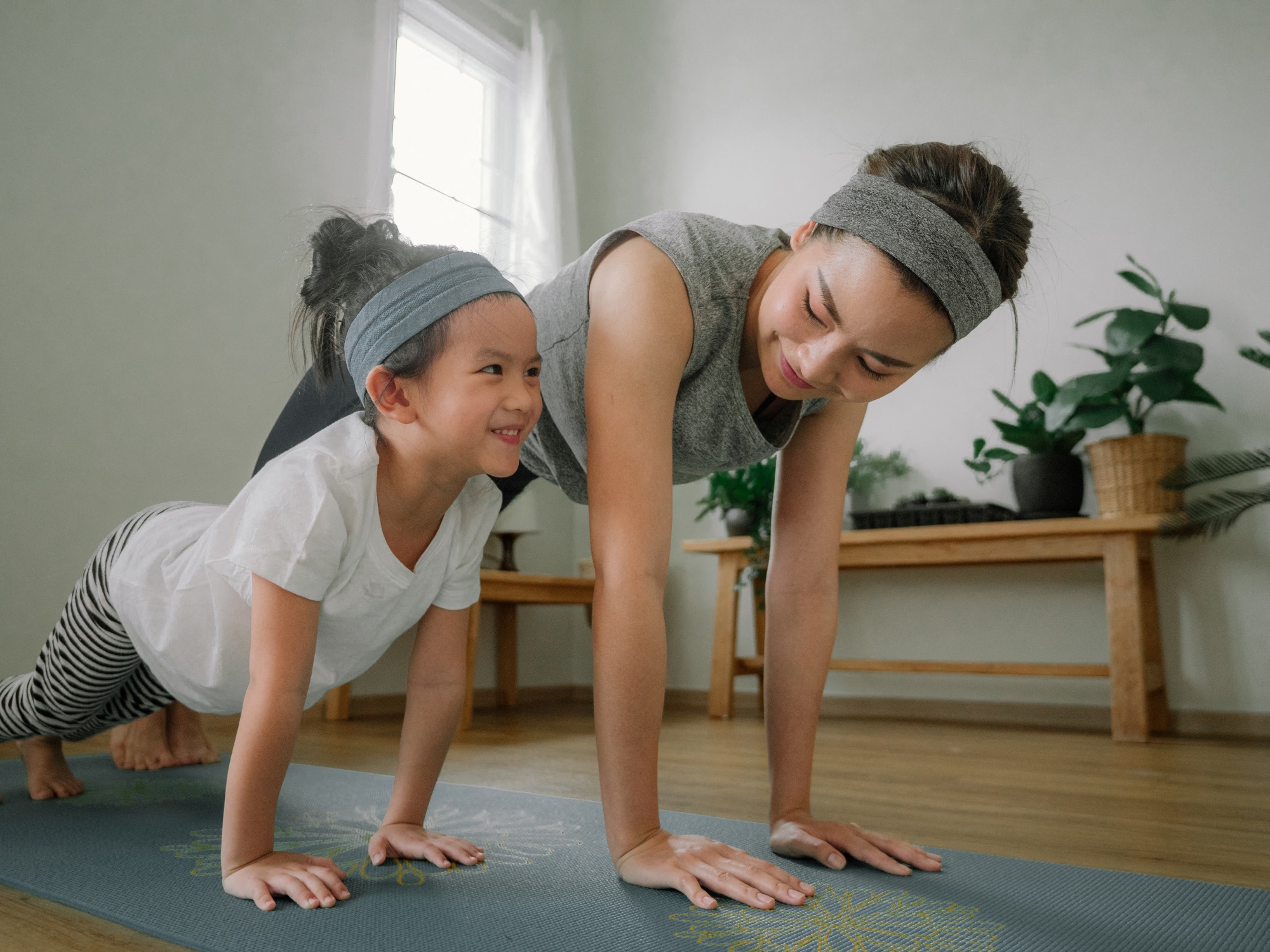 mother and daughter doing yoga at home