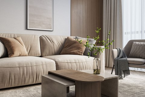 A living room with a beige sofa, a wooden coffee table, and a plant on the table.
