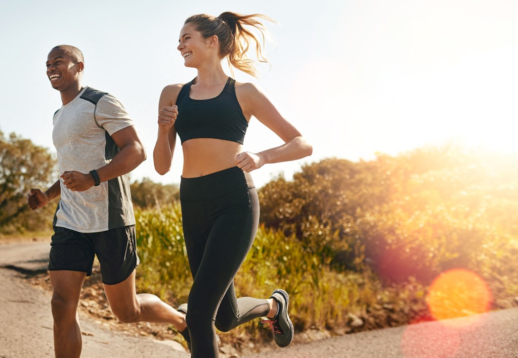 a man and a woman running on a road