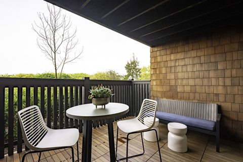 A patio with a table, two chairs and a bench.