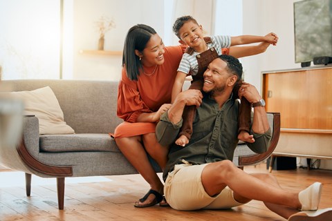 A family of three is having fun in their living room.