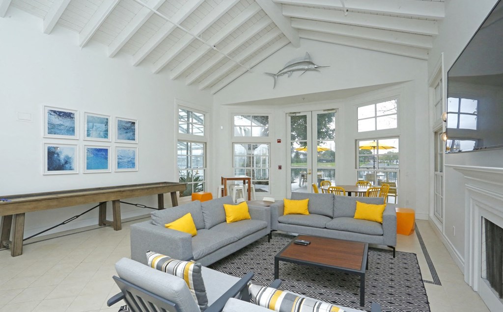 a living room with a gray couch and yellow pillows