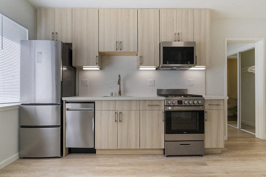 a kitchen with a stove a refrigerator and a microwave