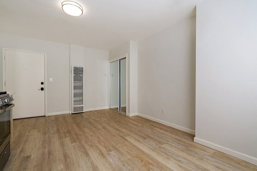 a bedroom with hardwood flooring and white walls
