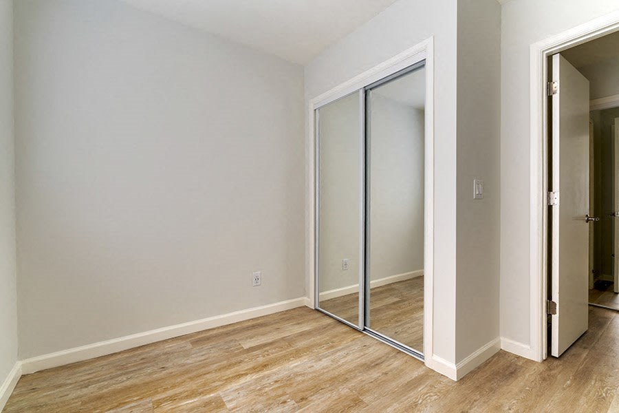 a bedroom with a sliding glass door and hardwood floors