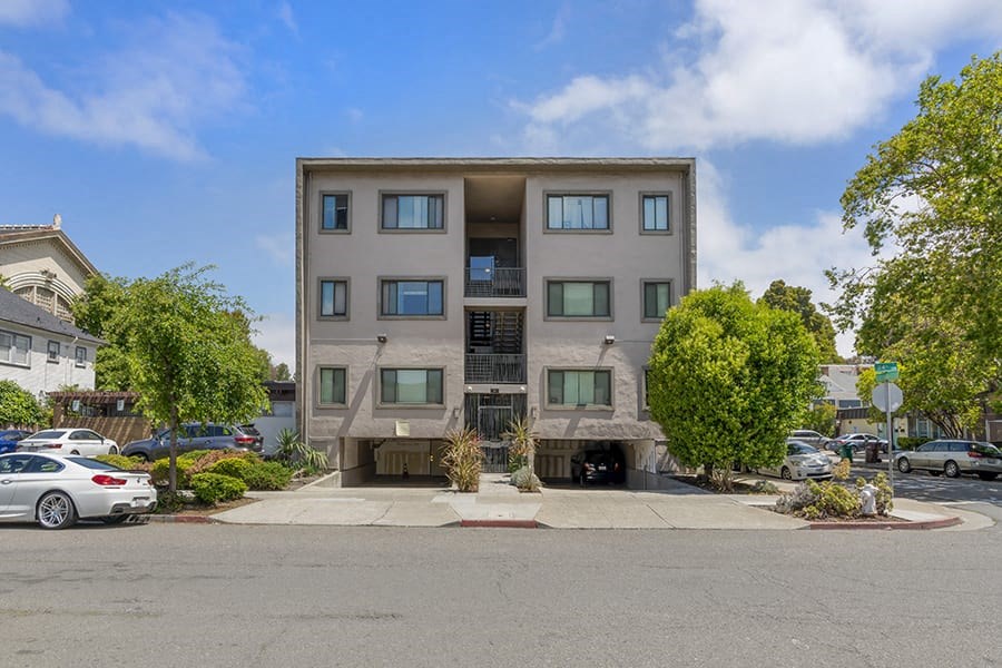 an apartment building with a parking lot in front of it