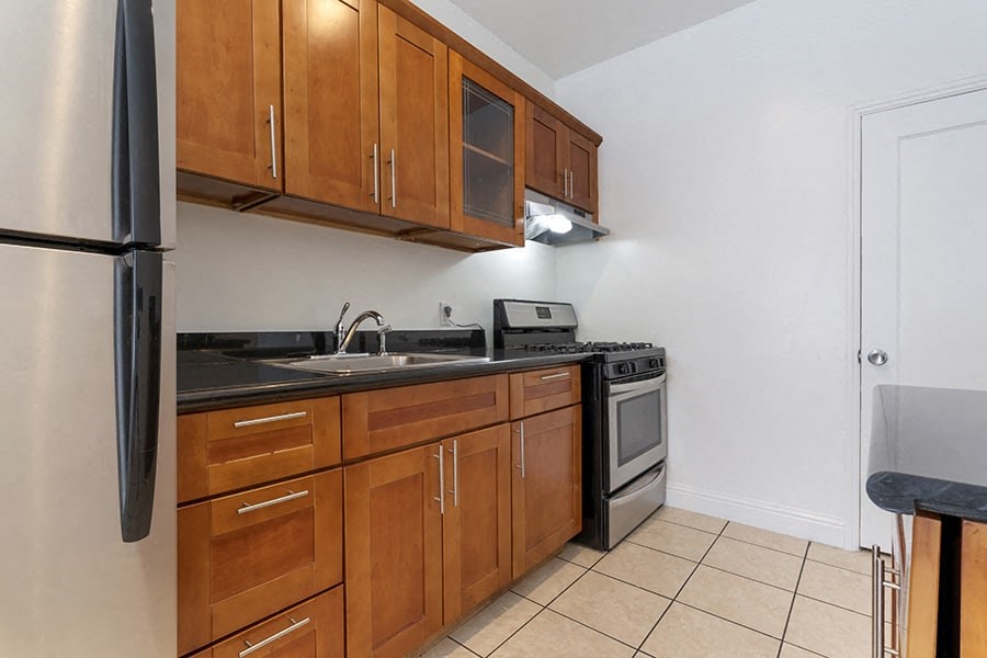 a kitchen with wooden cabinets and black countertops
