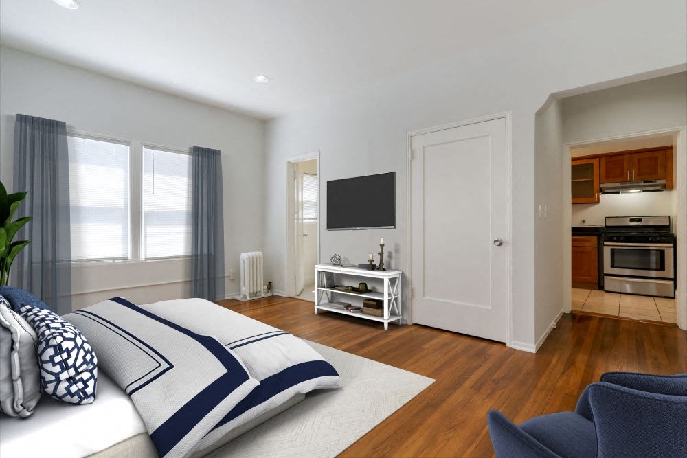 a bedroom with a bed and a chair in front of a tv