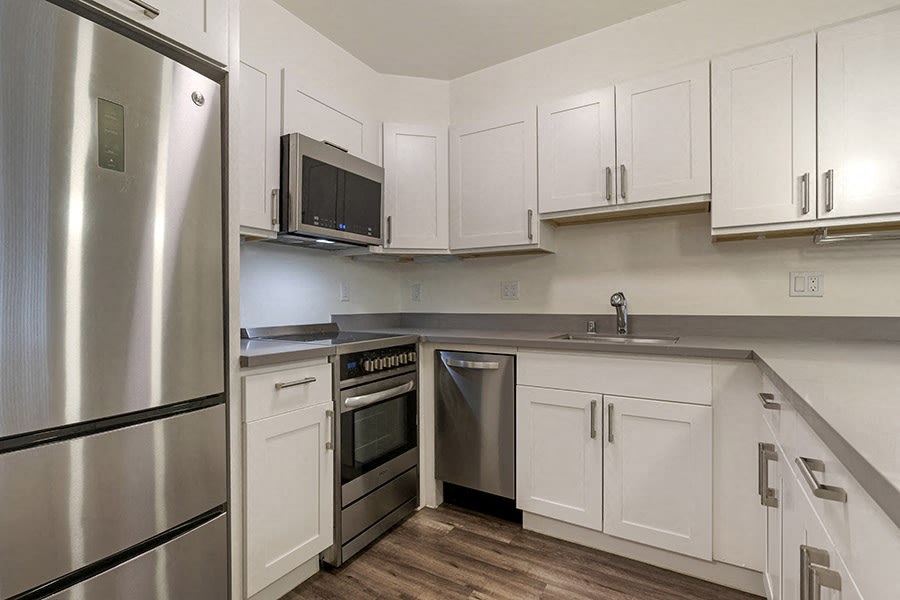a kitchen with white cabinets and stainless steel appliances