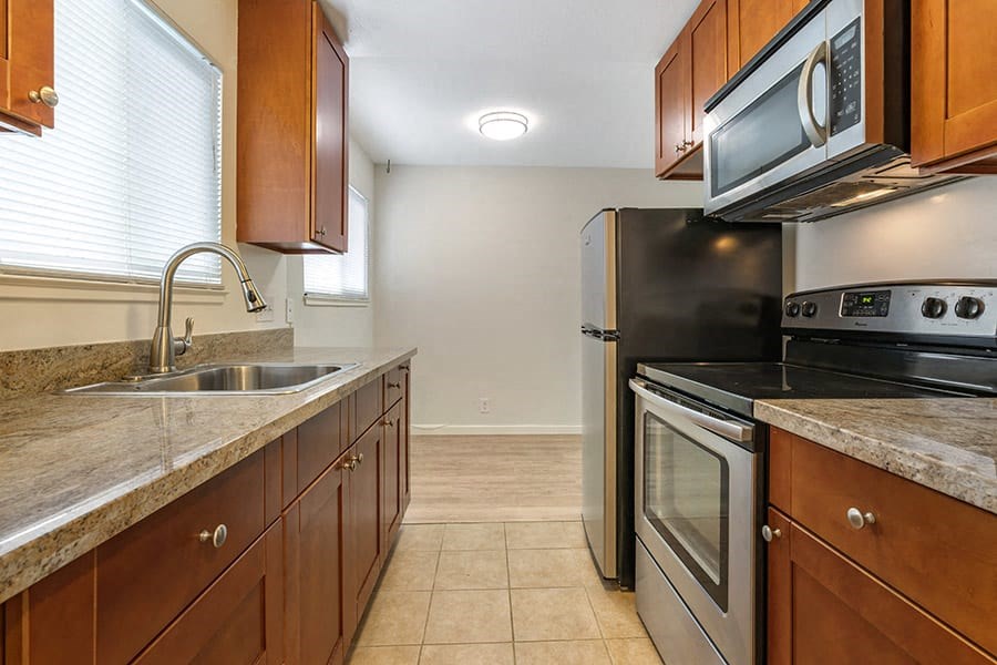 a kitchen with wooden cabinets and stainless steel appliances