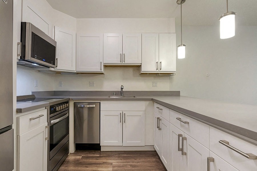 a kitchen with white cabinets and stainless steel appliances