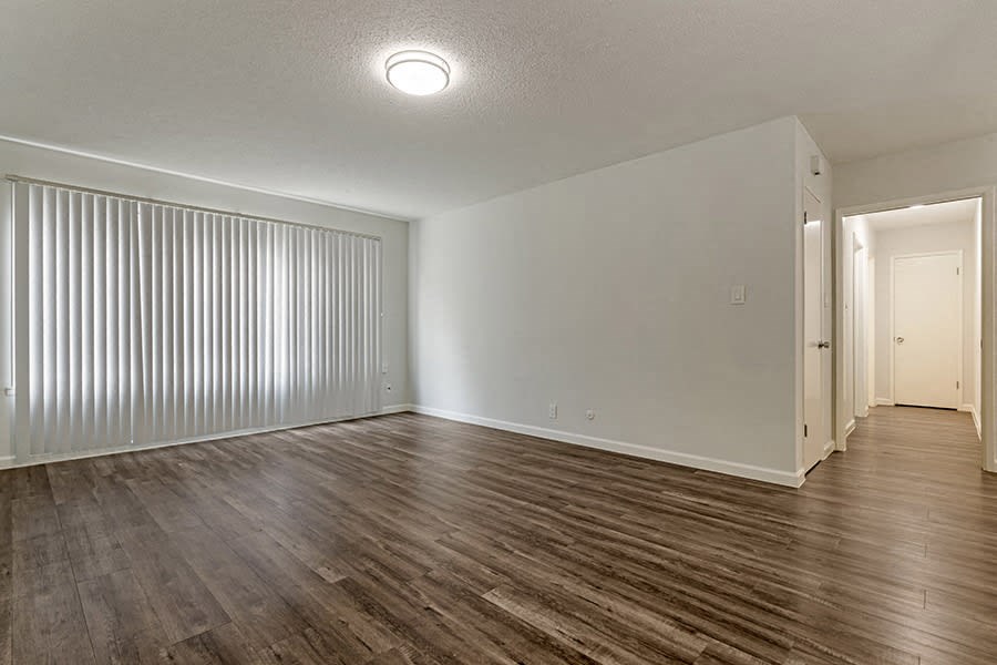 a bedroom with a large window and hardwood floors