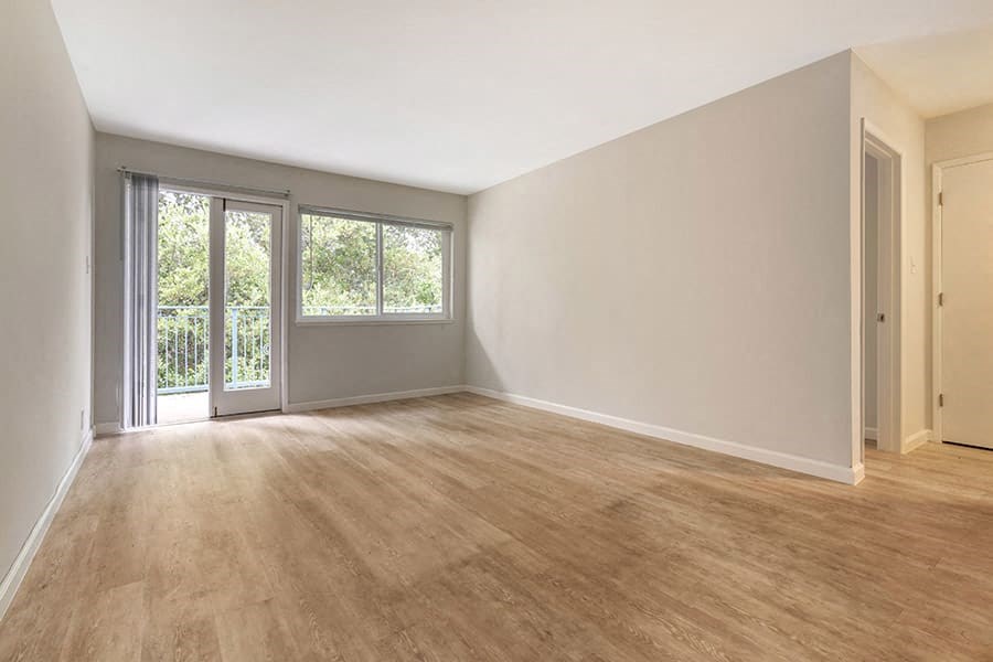 an empty room with a sliding glass door and a balcony