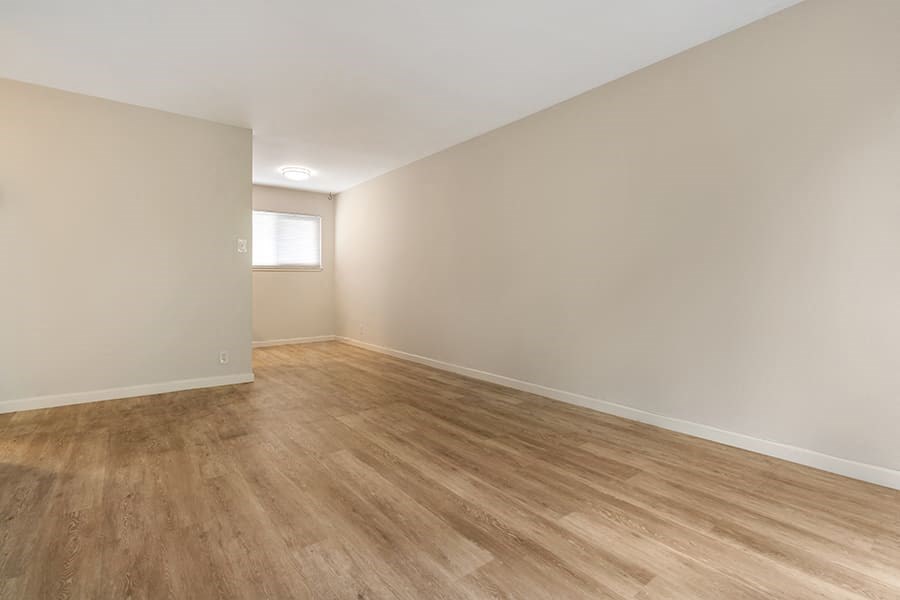 an empty room with a wooden floor and a window