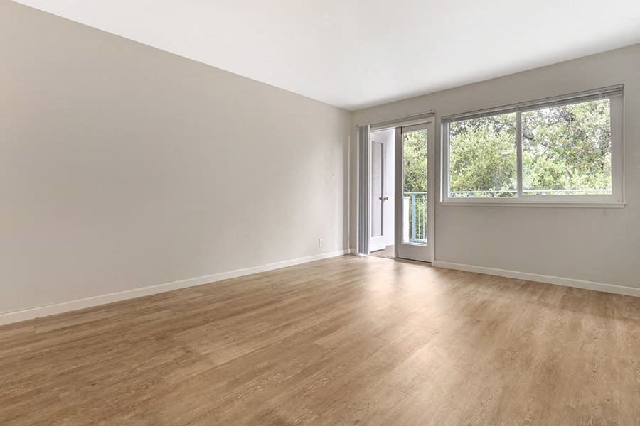 an empty room with a sliding glass door and a window