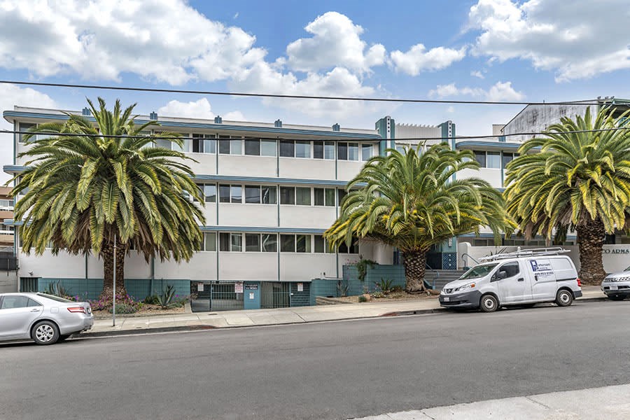 a large white building with palm trees in front of it
