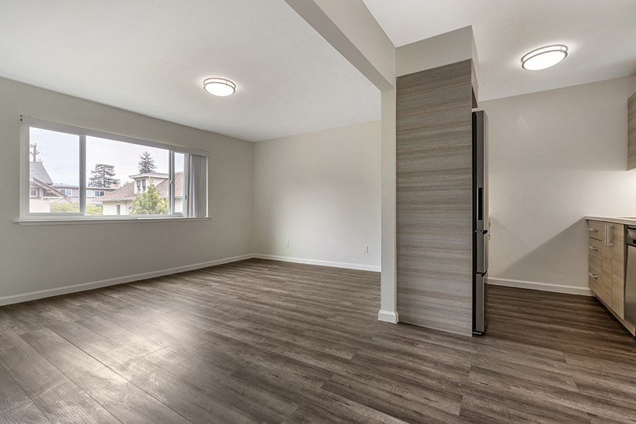 a bedroom with hardwood floors and a large window