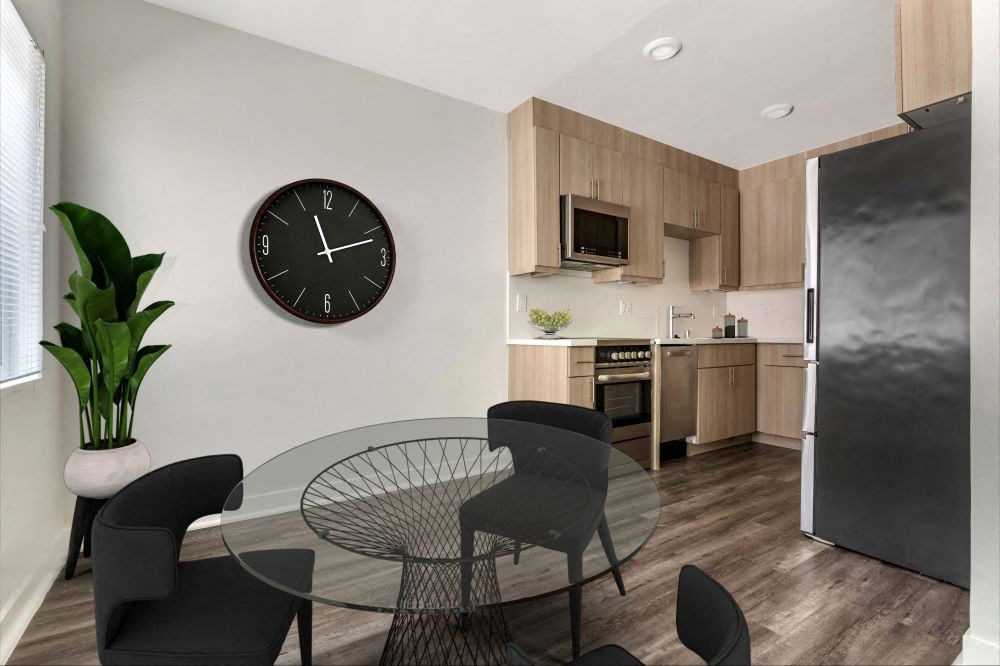 a dining area with a table and chairs and a clock on the wall