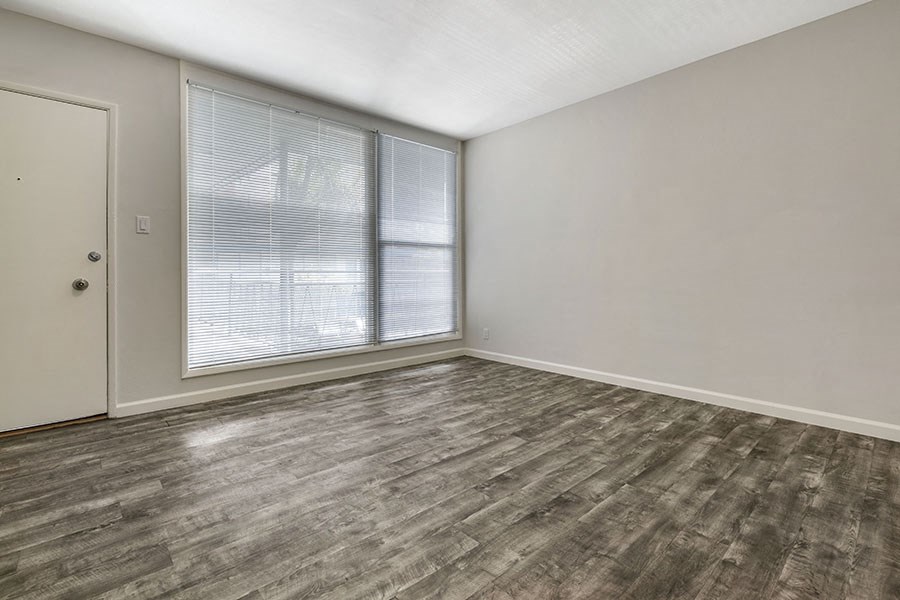 a bedroom with a large window and hardwood floors