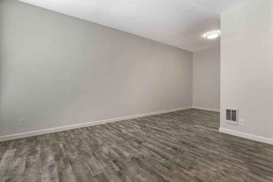 a bedroom with hardwood floors and grey walls