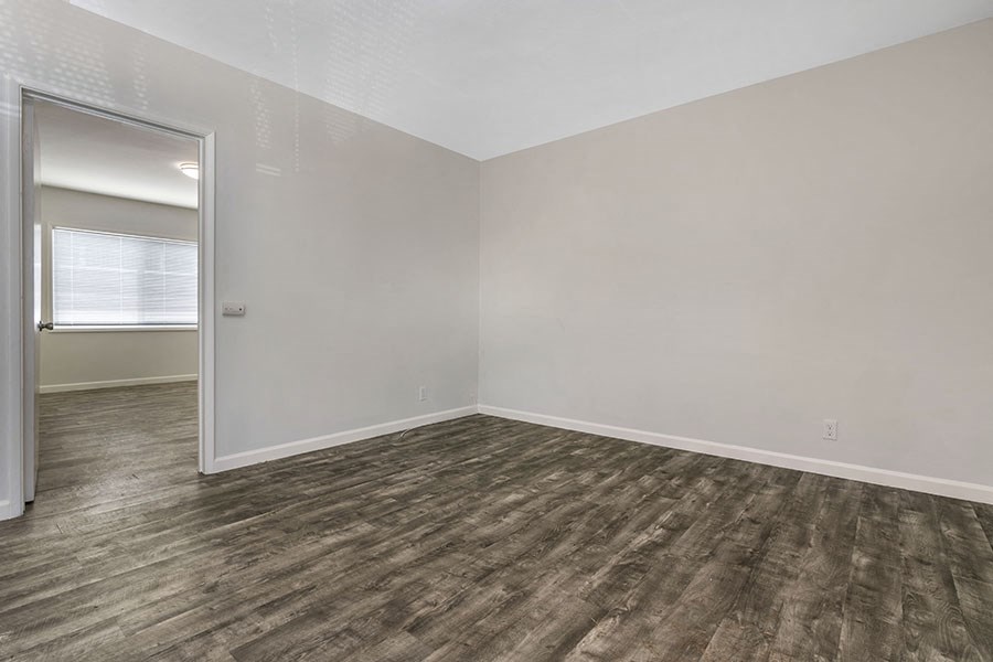 a bedroom with gray walls and a wooden floor