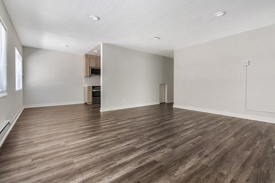 a bedroom with hardwood floors and white walls