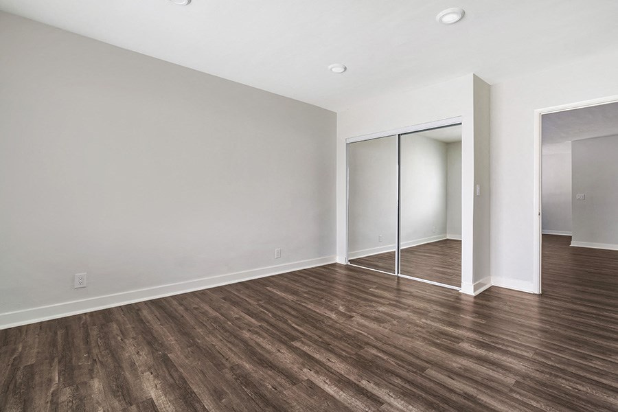 a bedroom with hardwood floors and grey walls
