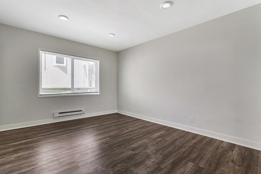 a bedroom with grey walls and a window
