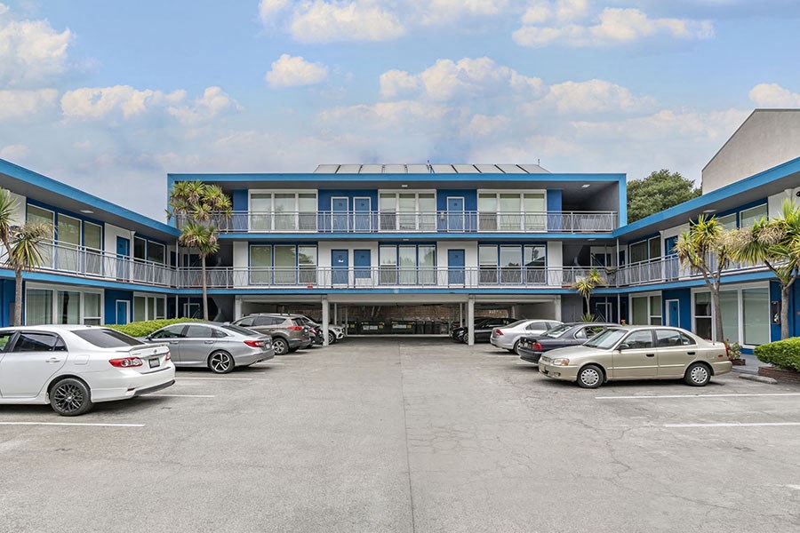 a blue building with a parking lot in front of it
