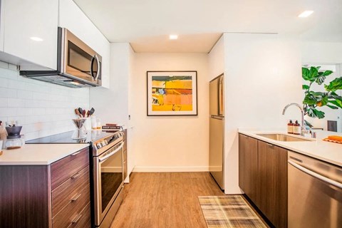 A kitchen with a modern design featuring a stainless steel oven and microwave.