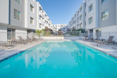 A swimming pool in front of apartment buildings at Woodley Sara Apartment, Van Nuys, CA, 91406