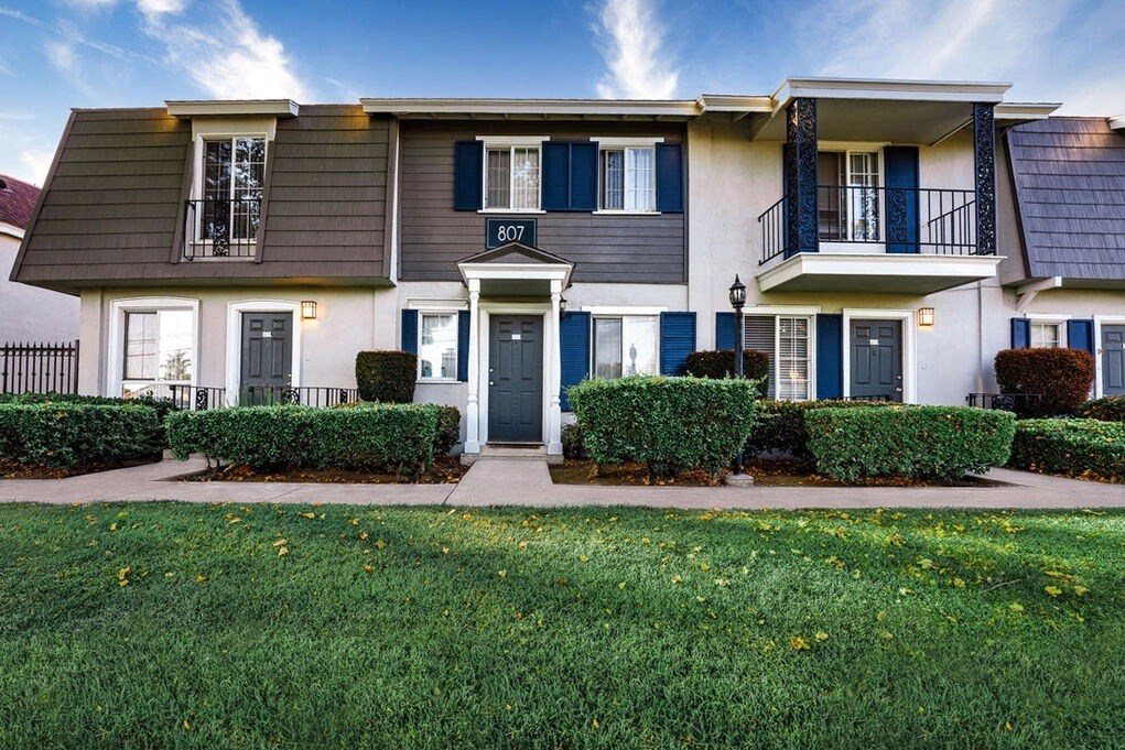 A row of houses with blue shutters and white walls at Nola 624 Apartments, West Covina, CA, 91790