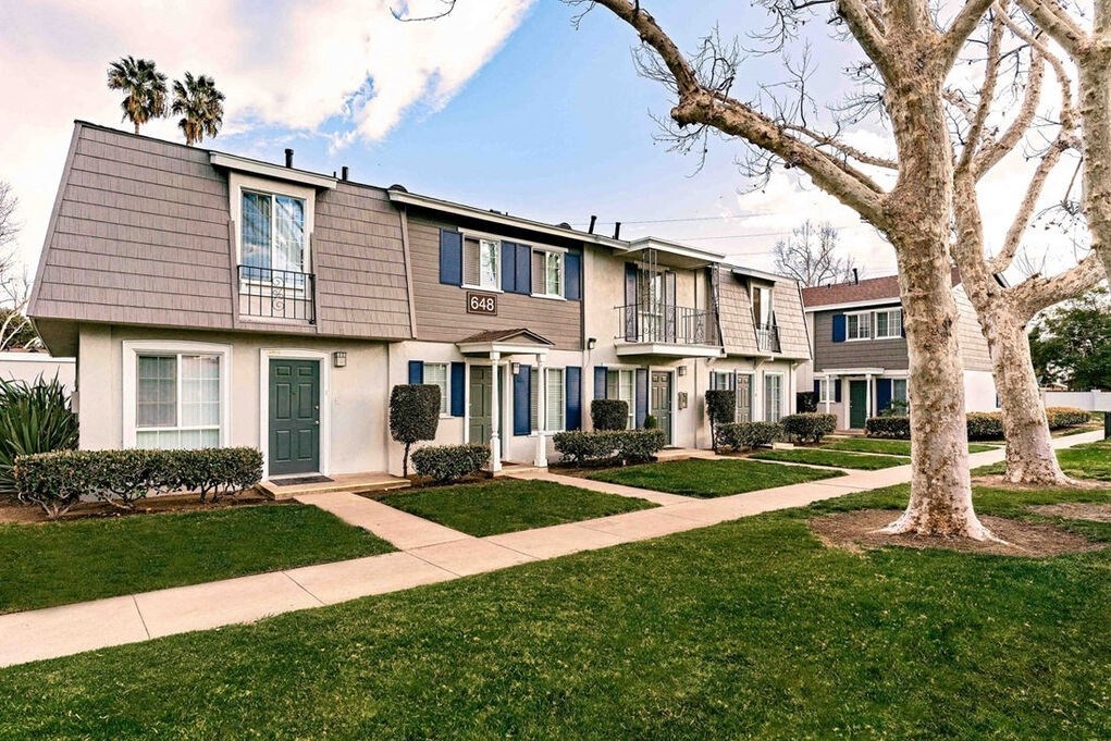 A row of houses with a tree in front of them at Nola 624 Apartments, West Covina