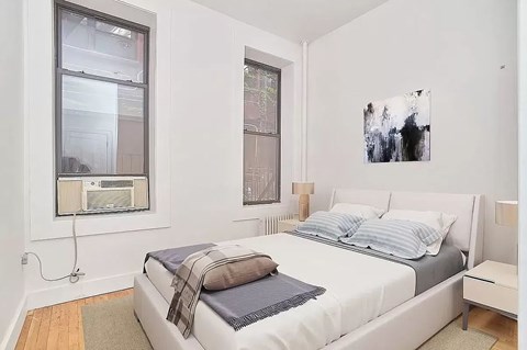 A bedroom with a large bed and a painting on the wall.