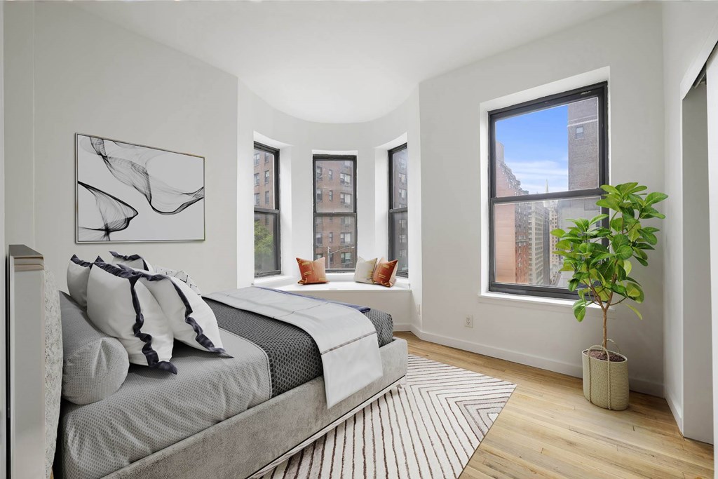 A bedroom with a large bed and a plant.