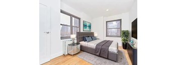 A bedroom with a bed, nightstand, and a painting on the wall.