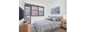 A bedroom with a large bed and a painting on the wall.