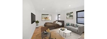 A modern bedroom with a large bed, a couch, and a TV mounted on the wall.