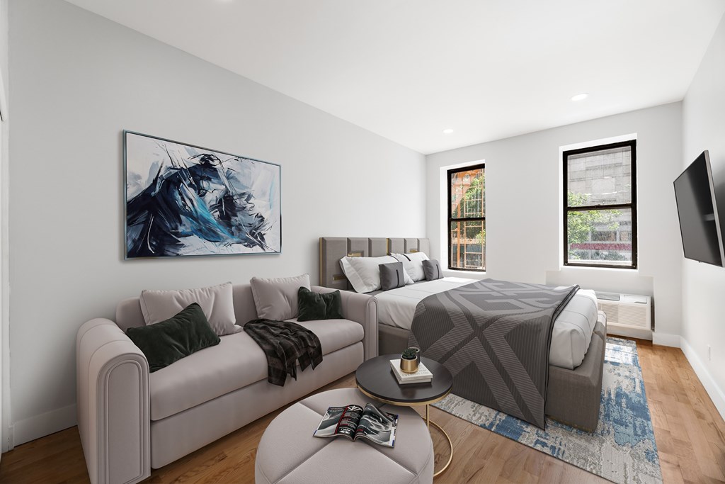 A modern living room with a grey couch, a coffee table, and a large painting on the wall.
