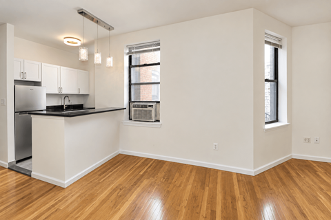 A kitchen with white cabinets and a black countertop.